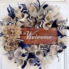 a welcome sign is hanging on the front door with paper flowers and ribbon around it