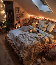 an attic bedroom is decorated with lights and blankets