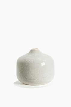 a white vase sitting on top of a table