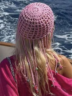 a woman sitting on top of a boat looking out at the ocean with long blonde hair