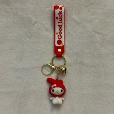 a hello kitty keychain is shown on a white sheet with a hello kitty tag