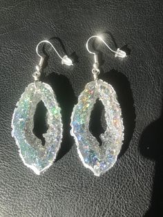 These geode inspired earrings are made with resin and give off an extremely sparkly silver opal vibe. The video does not do them justice! They are lightweight and won't bother your ears. Please note the color in the photos is with sun shining on them. They will not be quite as vibrant with no light shining on them, same as any glitter-it is reflected in the light. Made by Katie Glover Resin Art by Katie 2020 Contact me on my Instagram @123pour if you would like additional photos or videos of thi Geode Earrings, Sun Shining, No Light, Boho Festival, Handmade Art, Resin Art, Epoxy Resin, Druzy, Hippie Boho