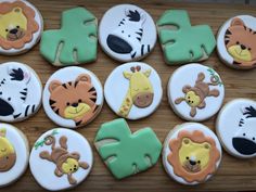 decorated cookies are arranged in the shape of letters and animals on a wooden table top