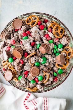 a bowl filled with christmas treats and pretzels on top of a white table