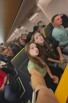 people are sitting on an airplane with their faces painted