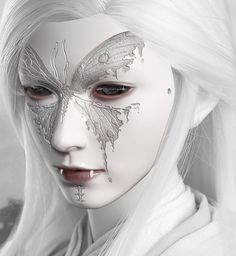 a woman with white hair and face paint is shown in black and white, while the image shows a butterfly on her face