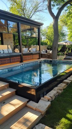 an outdoor swimming pool with steps leading up to it and a deck in the background