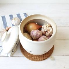 a bowl filled with onions and garlic on top of a wooden table