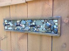 a wooden wall with rocks and gravel embedded in the metal frame on it's side