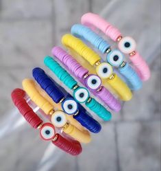 a bunch of bracelets that have different colored eyes on them