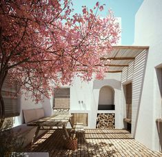 an artistic rendering of a patio with benches and trees in blooming red leaves on the tree