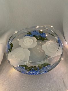 a glass bowl filled with flowers on top of a table