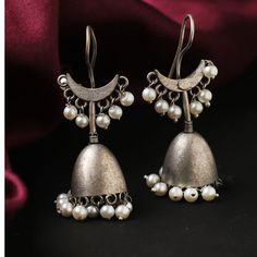 "Introducing our exquisite \"Oxidized Silver Plate Hook Drop Jhumka Jhumki Ethnic Earrings,\" a captivating blend of traditional charm and contemporary style. Elevate your jewelry collection with these intricately crafted earrings designed for women who appreciate the beauty of cultural aesthetics. These stunning jhumka jhumki earrings feature a unique oxidized silver plate, adding a vintage touch that complements both modern and ethnic ensembles. The carefully designed hooks enhance the overall appeal, providing a secure and comfortable fit. The fusion of tradition and trend is beautifully showcased in the delicate pearl embellishments, adding a touch of elegance and grace to these statement earrings. Whether you're dressing up for a special occasion or looking to add a touch of glamour t Luxury Traditional Jhumkas With Zari Work, Cheap Festive Metal Jhumkas, Luxury Silver Temple Jewelry Jhumkas, Luxury Traditional Jhumkas With Intricate Design, Luxury Traditional Jhumkas For Wedding, Luxury Traditional Jhumkas, Brass Jhumkas For Rituals And Festivals, Bohemian Oxidized Jhumkas For Wedding, Silver Brass Jhumkas With Tilla