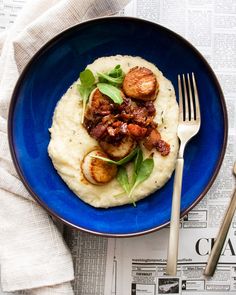 a blue plate topped with mashed potatoes and bacon