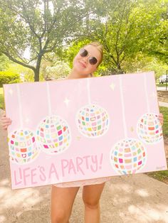 a woman holding up a sign that says life is a party