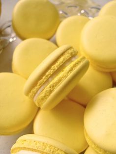 yellow macaroons are arranged in a pile on top of each other, and one is half eaten