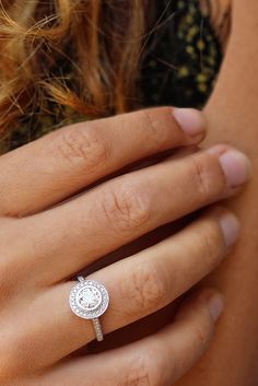 a woman's hand with a diamond ring on it