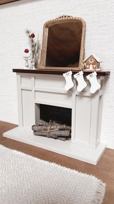 a white fireplace with stockings on the mantle