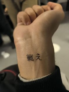 a person with a wrist tattoo that has chinese characters written on the side of their arm