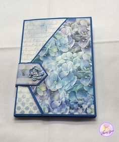 a close up of a card with blue flowers and writing on the back side,