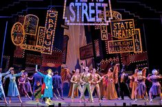 a group of people standing on top of a stage in front of a sign that says new york's street