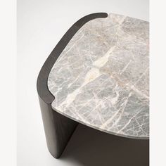 a white marble table with black wood trim