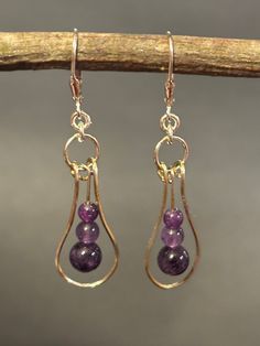 Artisan designed and handcrafted these original purple Amethyst Minimalist Earrings. Sterling silver unique structural design is a hoop with purple amethyst beads. The bottom bead is 6 mm the center 4mm and the top bead is 3 mm. A jump ring connects the component with the Sterling silver lever back earring wire.  These earrings are dainty minimalist designed and a great gift.  Overall measurement length 2 inches long including sterling silver lever back earring wire. Width 1/4 inches wide and dr Acrylic Nails Almond Shape, Earrings Diy Handmade, Jump Ring Jewelry, Almond Acrylic Nails, Amethyst Beads, Handmade Wire Jewelry, Amethyst Gemstone, Minimalist Earrings, Purple Amethyst