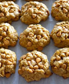 several cookies with nuts are lined up on a baking sheet and ready to be eaten