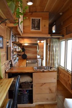 a small kitchen with wooden walls and flooring