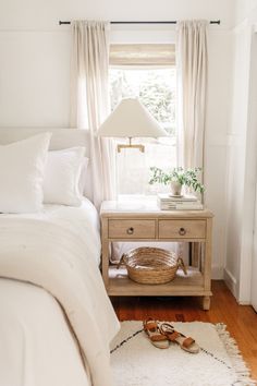 a bedroom with a bed, nightstand and window