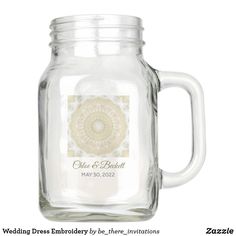 a glass mason jar with a white lid and an intricate design on the bottom, holds a