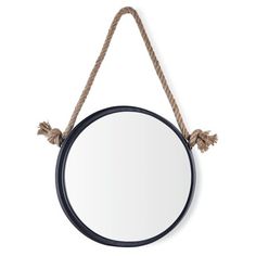 a round mirror hanging from a rope on a white wall with a black frame and two brown tassels