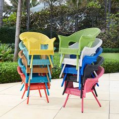 colorful chairs are stacked on top of each other in the middle of a patio area