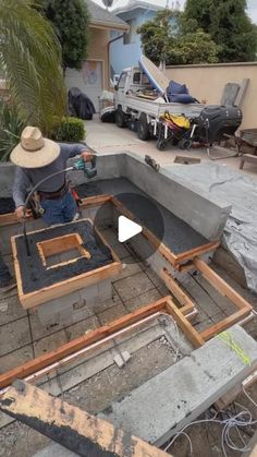 a man in a hat is working on a house construction project with concrete and wood