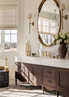 a bathroom with a large round mirror above the sink