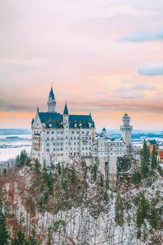 a large white castle sitting on top of a snow covered hill