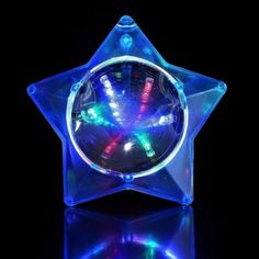 a star shaped light up clock on top of a black surface with blue and green lights