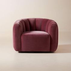 a red chair sitting on top of a floor next to a white wall and beige walls