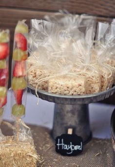 there is a cake on the table with strawberries and grapes in plastic bags next to it