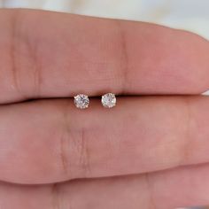 "Lovely two round brilliant cut diamonds, which are handset in 14k white gold basket mountings with push-backs. The diamonds are G-H in color and I1 in clarity. Earrings Available in natural diamond or clear cubic zirconia, please specify when placing your order. Height: 3mm Width: 3mm Thickness: 2.5mm Stone material: Center stone size: 3mm Stone shape: round Center stone carat weight:0.08 ct each Total number of CZ stones: 2 Total diamond weight: 0.16 Ctw Stone setting: prong setting Metal: Sol Minimalist Solitaire Diamond Earrings, Minimalist 14k Gold Diamond Earrings With Prong Setting, Rose Gold Diamond Earrings With Single Round Cut, Minimalist Solitaire Cubic Zirconia Diamond Earrings, Minimalist Round Cut Diamond Earrings With Accents, Minimalist Cubic Zirconia Solitaire Diamond Earrings, Minimalist Single Diamond Earrings From Lab Grown Diamonds, Minimalist Solitaire Diamond Earrings In White Gold, White Gold 14k Diamond Earrings With Single Diamond