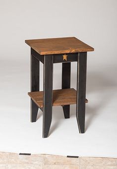 a small wooden table sitting on top of a tile floor next to a white wall