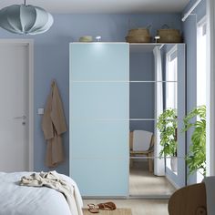 a bedroom with blue walls and white furniture