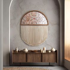 a room with a table, vases and a mirror on the wall above it