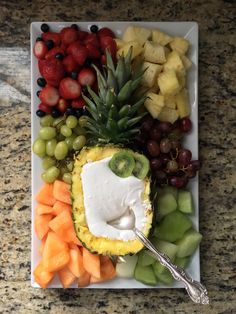 a plate with grapes, pineapple, melon, kiwi and other fruits