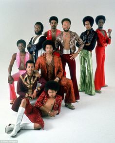 a group of men and women posing for a photo in front of a white background