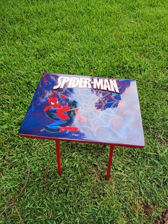 a spiderman table sitting in the grass