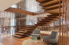 a living room filled with furniture next to a spiral stair case on top of a hard wood floor