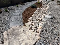 a garden with rocks and gravel in the middle