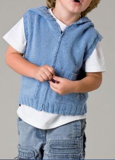 a young boy wearing a blue sweater vest