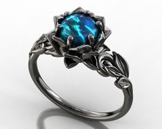 "Looking for a unique engagement ring to begin your life with your special love? Look no further than this amazing Australian Black Opal Black Gold Lotus ring. With its unique shape and sparkling Natural Black opal, it makes a one of a kind statement of your love and commitment. The band is created of solid, 14kt black gold, carved at the top into an elaborate design of leaves. The design draws the eye toward a center of black gold petals. The highlight of this piece is the rare black opal (Aust Black Ring With Tension Setting As Gift, Black Ring With Tension Setting For Gift, Gift Black Ring With Tension Setting, Formal Black Opal Ring, Elegant Black Opal Ring As Gift, Elegant Black Opal Ring Gift, Elegant Black Opal Ring For Gift, Black Opal Engagement Ring, Engagement Ring Leaf